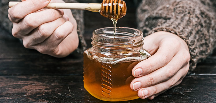 Person holding a honey jar