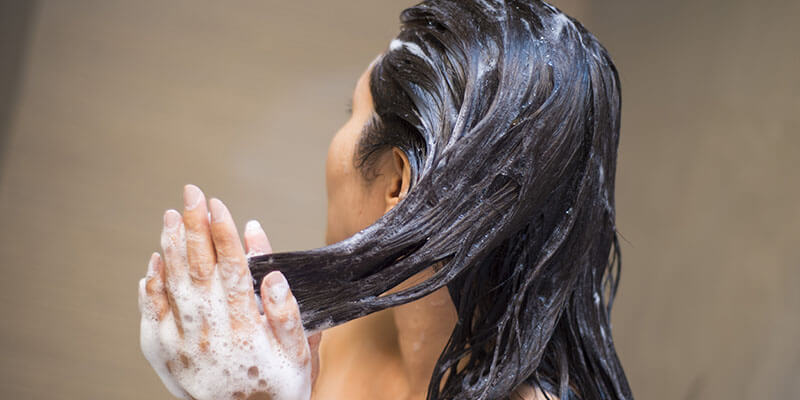 Woman shampooing hair extensions